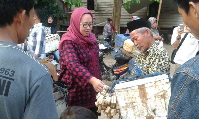 Camelia saat mengobrol dengan salah seorang pedagang ikan keliling di Lubuk Ruso